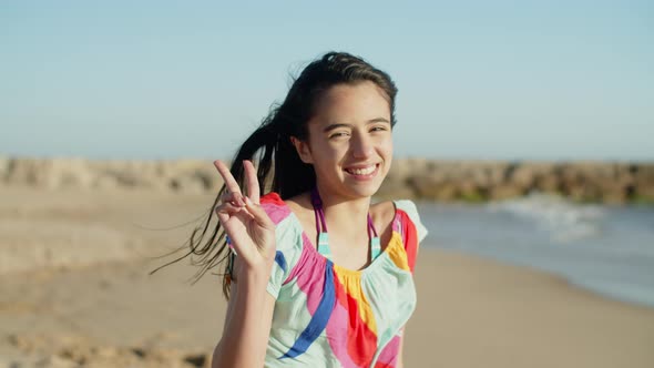 Medium Shot of Pretty Smiling Teenage Girl Sitting on Beach alt