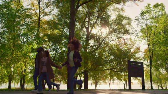 African American Parents Holding Hands Walking Run Green Park Walkway Together alt