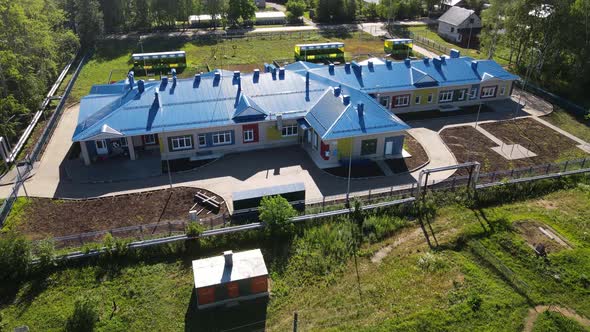 Aerial View on Modern Kindergarten Building with Blue Roof in Countryside