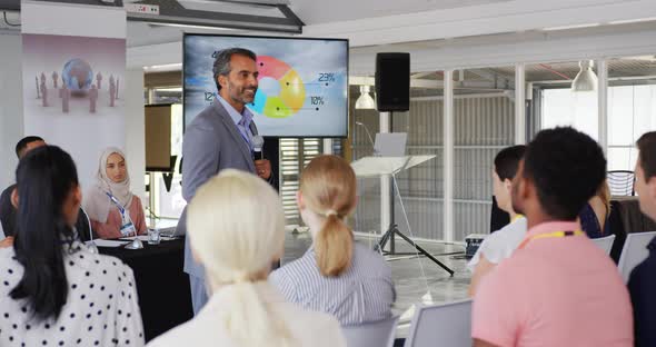 Male speaker addressing the audience at a business conference alt