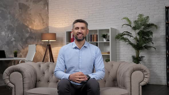 Portrait Smiling Man Stock Trader Broker Looking at Camera Sitting on Couch alt