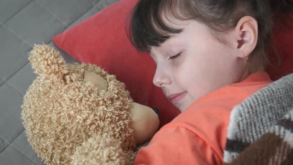 Teddy bear by sleeping child.  alt