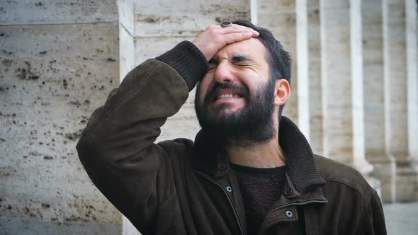 desperate man brings his hand to his forehead in the city. forgetfulness alt
