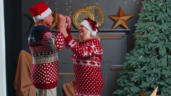 Joyful Senior Family Grandparents Couple Dancing at Home Near Christmas Tree Celebrating New Year alt