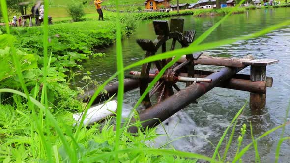 Wooden water wheel turning under power, water mill on a Lake.