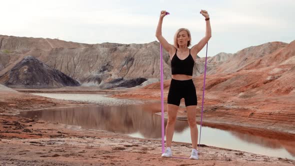 Woman working out on lifeless dried locality