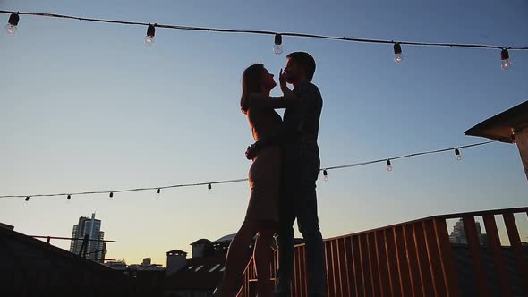 Couple Kissing While Standing on Rooftop During Sunset