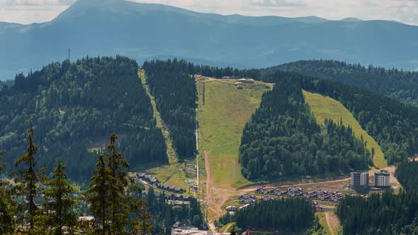 Mountain with ski slopes and working cable car lift, ski trails
