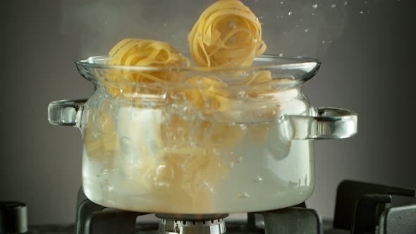 Super Slow Motion Shot of Fresh Pappardelle Falling Into Boiling Salted Water at 1000 Fps alt