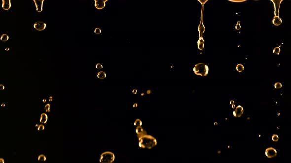 Super Slow Motion Shot of Falling Golden Droplets Isolated on Black Background at 1000 Fps alt