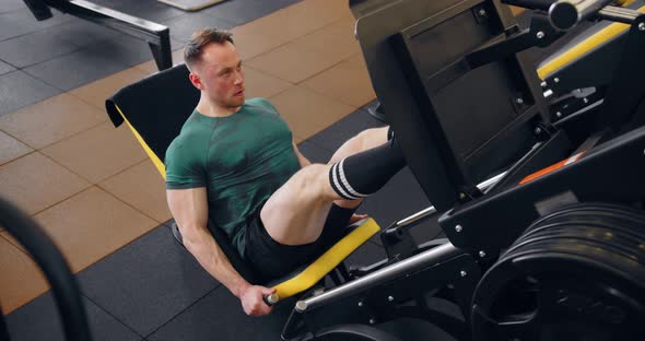 A Young Pumped Up Athlete Does Another Leg Exercise In The Gym In Preparation For Competition. alt