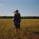Woman in ukrainian national clothes acting on camera on a wheat field