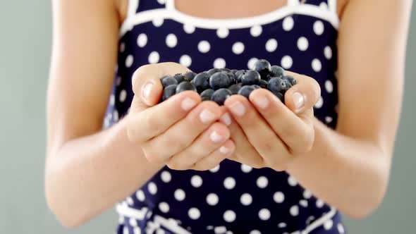 Close-up of woman holding blueberry alt