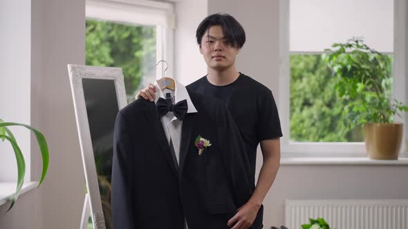 Portrait of Confident Happy Asian Young Groom Posing with Wedding Suit Indoors in the Morning alt