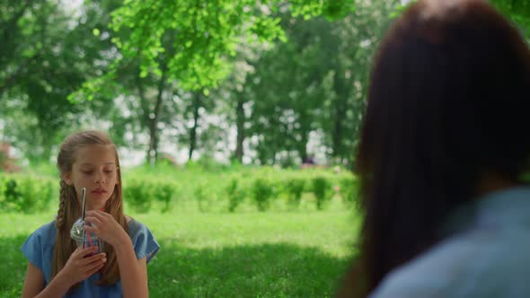Tranquil Girl Holding Drink on Picnic Close Up alt