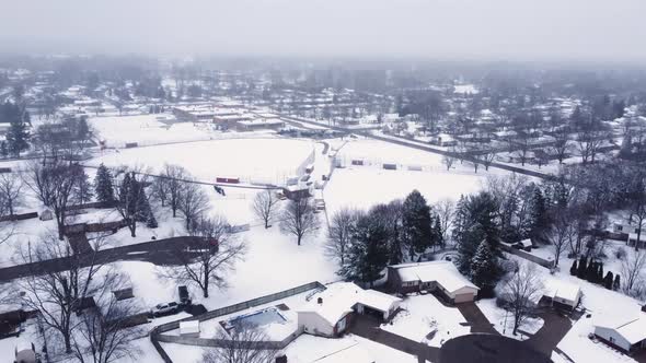 4K drone video of snow-covered baseball field at a school in winter in ...