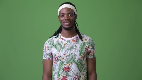 Young Handsome African Man with Dreadlocks Against Green Background alt