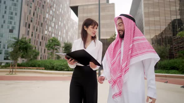 Young European Business Woman Making Successful Deal with Arab Man Client at Outdoor Meeting alt