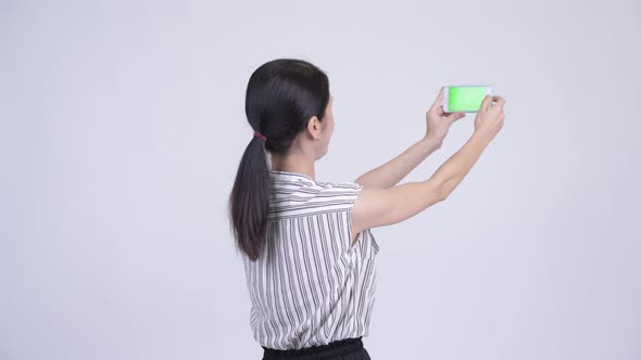Happy Beautiful Asian Businesswoman Taking Picture with Phone alt