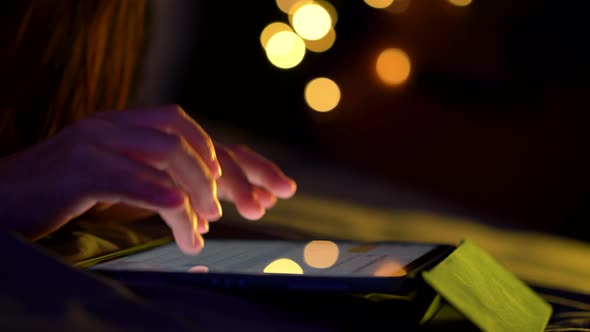 Close up shot of female hand using tablet touching and typing on screen.