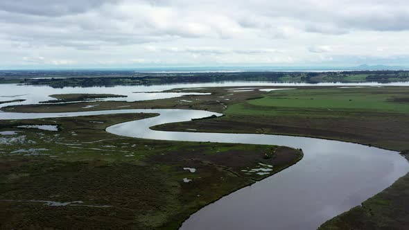 AERIAL Truck Left Over Lake Estuary Spilling Out To A Winding River alt