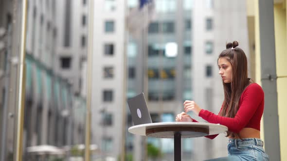 Freelancer Woman in a Summer Cafe Doing Remote Work alt