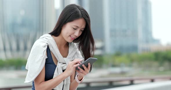 Woman use of mobile phone in city alt
