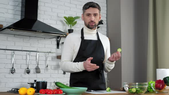 Man chef food teacher sliced cucumber in kitchen teaches online videocall webcam alt