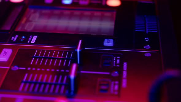 DJ Hand Presses Button and Moves Fader on Mixer Console in Disco Club Closeup alt