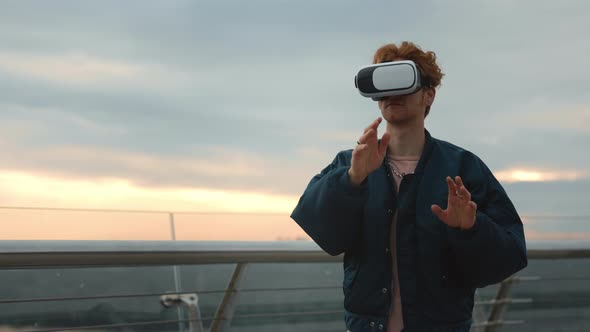 Young Man in VR Headset Standing on City Street alt
