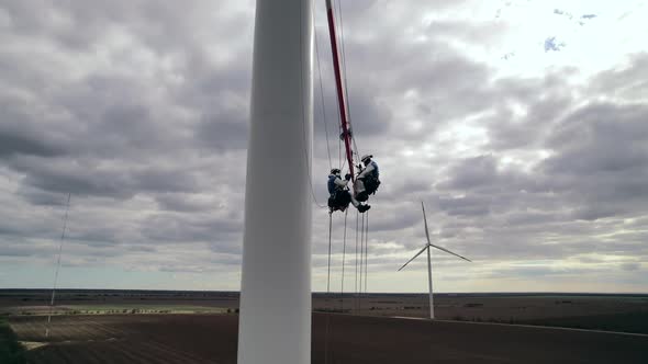 Builders Repair Winddriven Turbine Blade Under Cloudy Sky