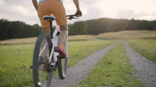 Slow Motion Detail Woman Cycling on E Mountain Bike in Rural Landscape Back View