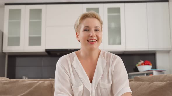 Cheerful Lady Having Video Chat While Sitting on Couch alt