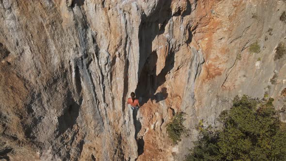 Aerial View From Drone of Strong Muscular Young Man Hanging on Rope and Descenting After Climbing on alt