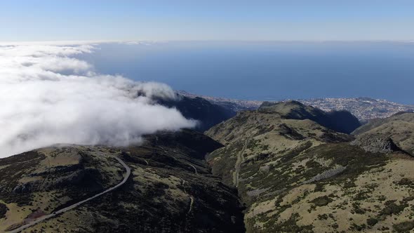 Clouds over Madeira mountains, Funchal city in the background, Portugal alt