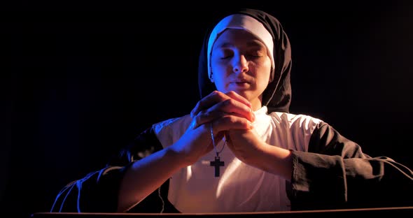 Nun Praying In The Dark In A Chuch
