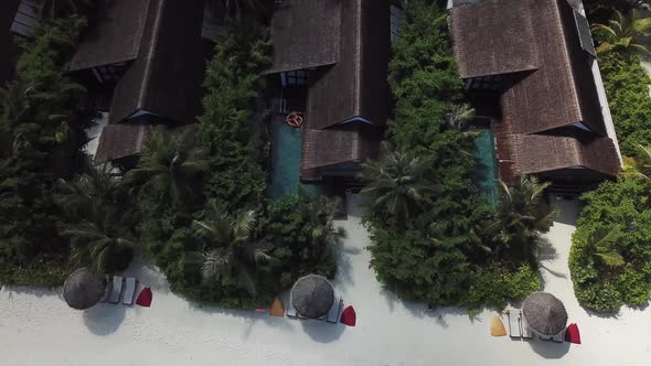 Tropical zoom in drone shot of a pool in a villa on a Maldives island 4K alt