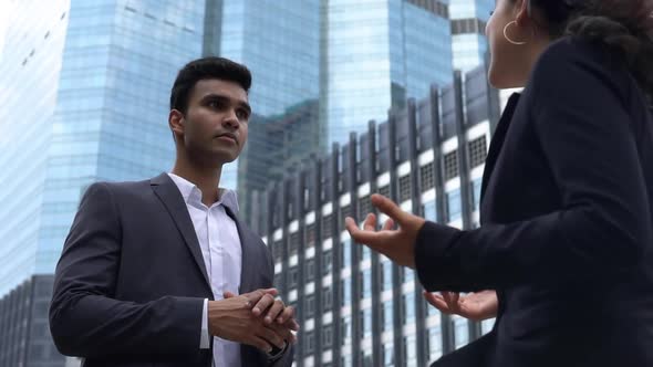 Happy young Indian businessman giving a high-five to his female colleague