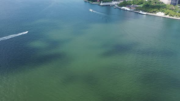 A bird's eye view directly over Upper Bay with two boats sailing by. The clouds cast their shadows o alt