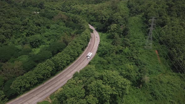 Aerial view of countryside road passing through the lush greenery and foliage tropical rain forest m alt