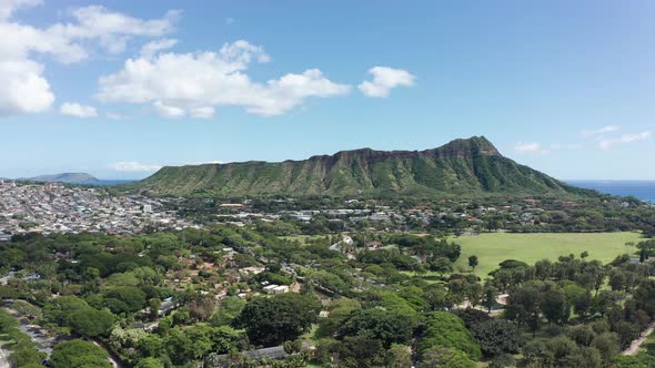 Wide rising aerial shot of the Diamond Head volcanic formation from Waikiki Beach on the island of O alt