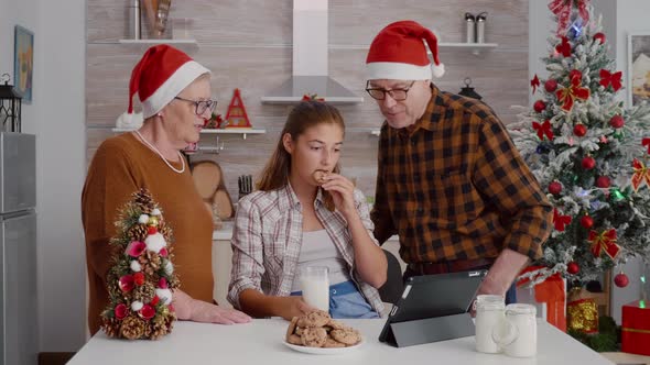 Happy Family Watching Online Xmas Movie on Tablet Computer Enjoying Holiday Season alt