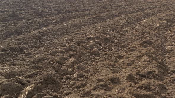 Slow flight above the plowed earth 4K drone video alt