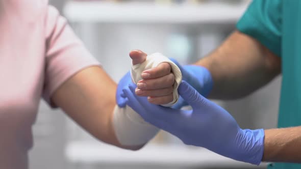 Doctor Examining Female Patient Arm in Elastic Bandage, Joint Injury, Trauma