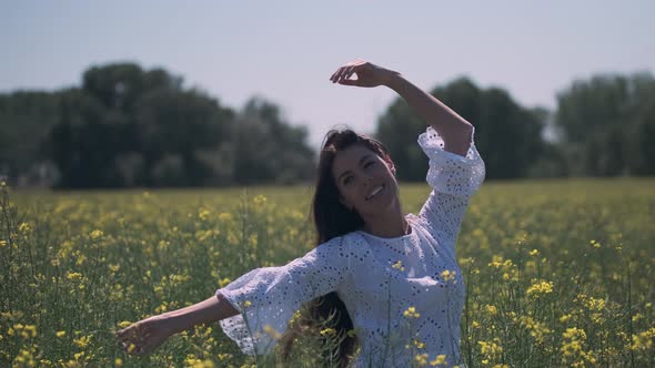 Pretty young woman in the rapeseed field