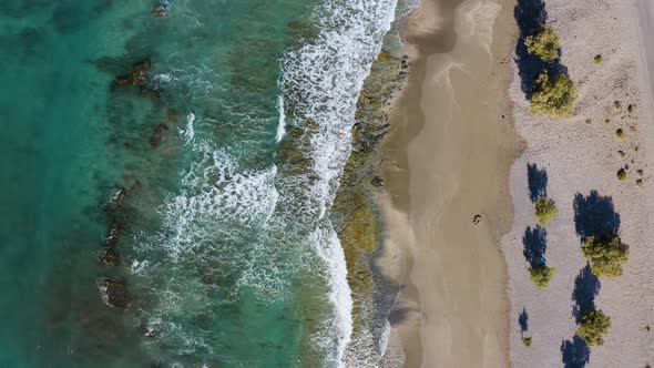 Flying above Beach and Sea cost line. Aerial of waves crushing against the coast line. alt