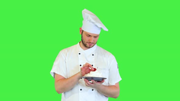 Young Cook or Chef in Uniform Presenting Delicious Dessert Cream Decorated with Fresh Strawberry on