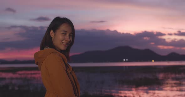 Asian lady with backpack feeling happy smiling to camera in camping on beach at night.
