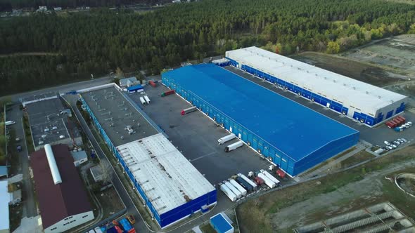 Aerial Top View of the Large Logistics Park with Warehouse with Some Semi-trailers Trucks.