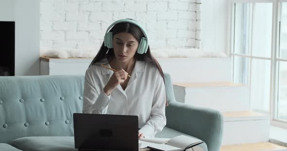 Young Woman Freelancer Talking with Client Making Video Remote Call and Writing Notes to Improve the alt